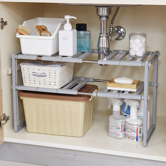 Expandable two-tier organizer fitted around plumbing beneath a sink