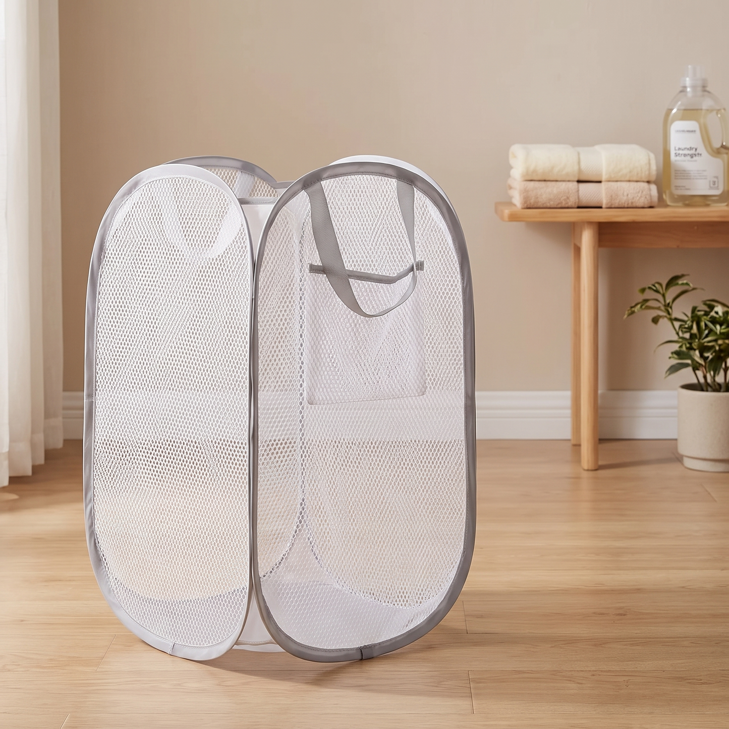 White foldable mesh storage basket standing open in a laundry room